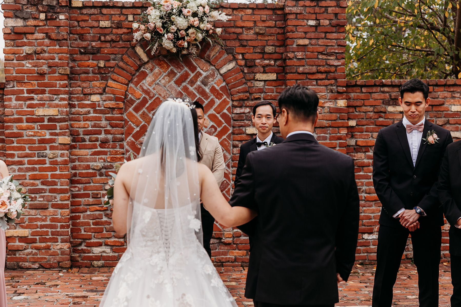 grooms reaction as bride walks down the aisle, shot from over the brides shoulder 