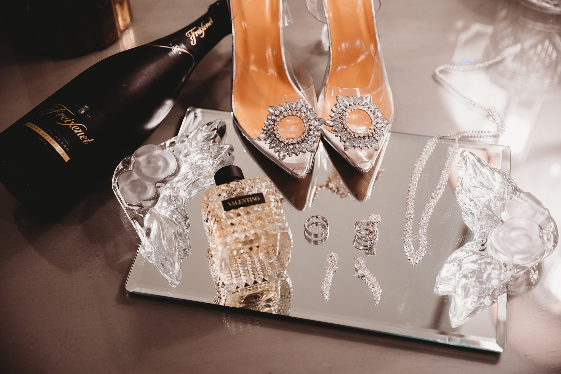 a mirror tray with the brides shoes and jewelry resting on it