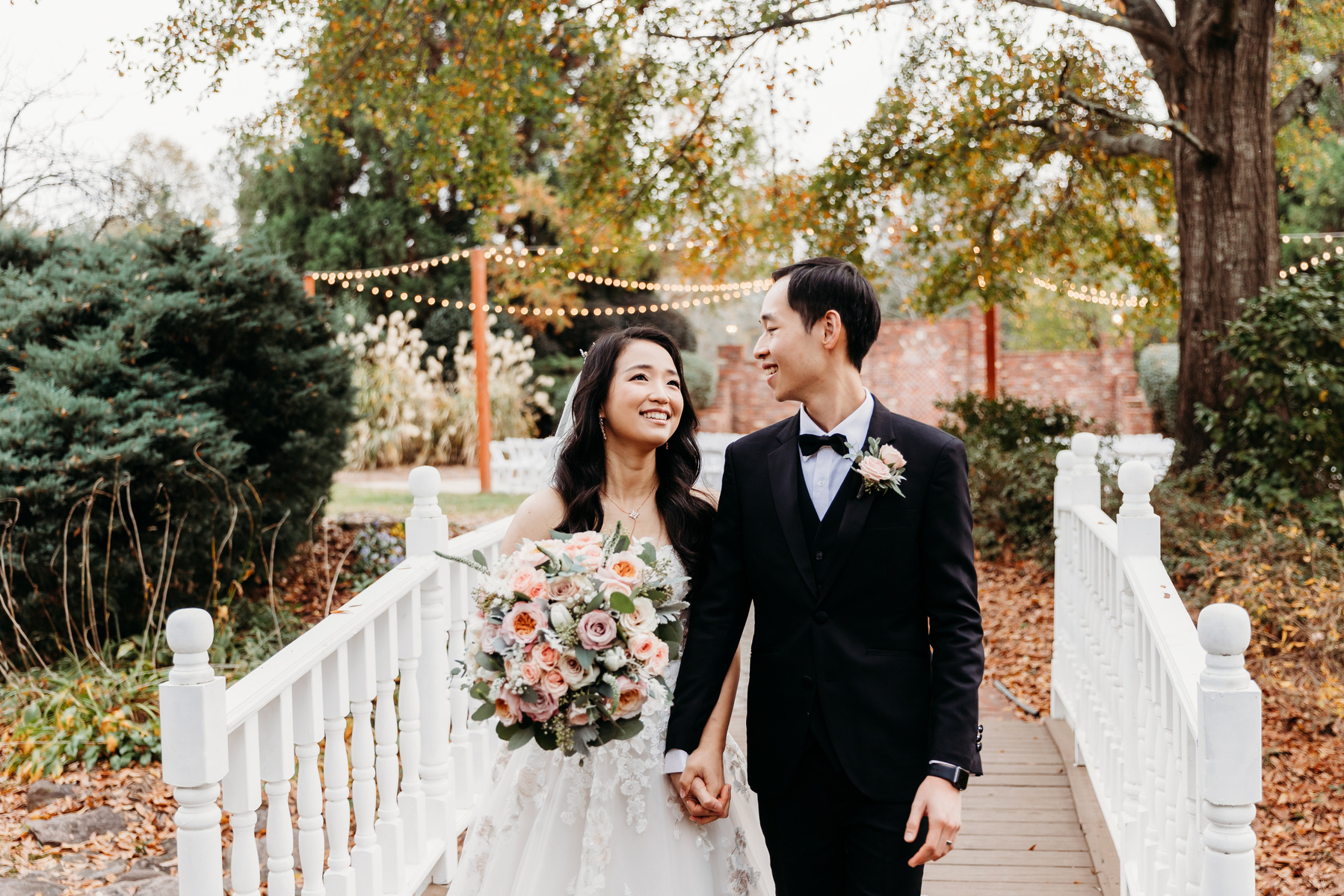 bride and groom on a white bridge, looking at each other