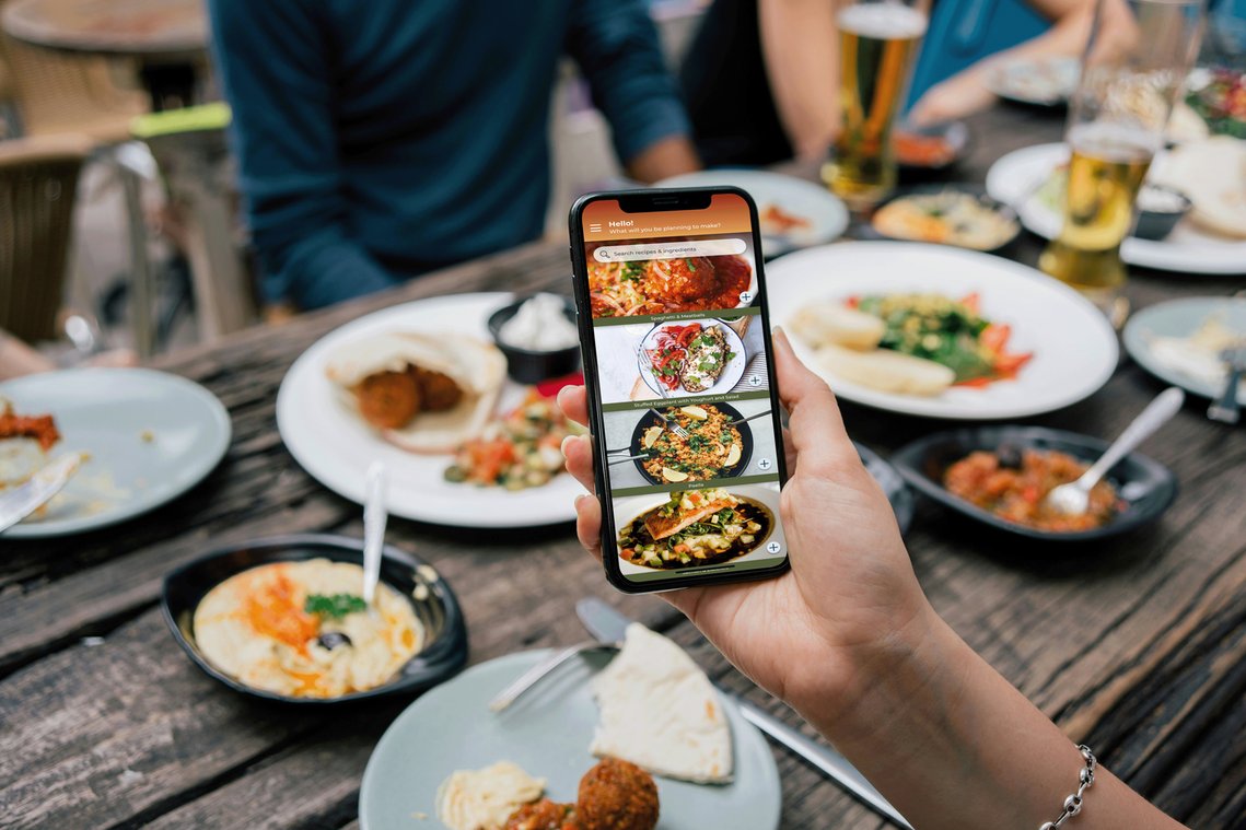 Hand holding phone with food images