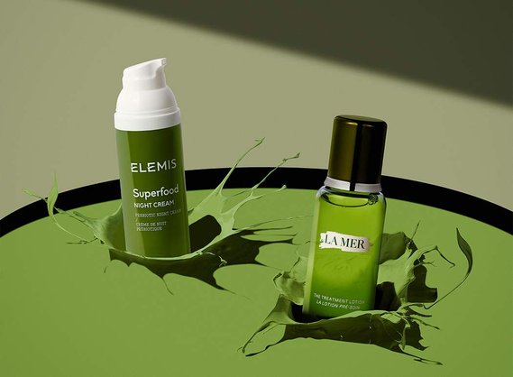 A striking falling pair of cosmetics by La Mer and Elemis falls and a splash of green liquid. 