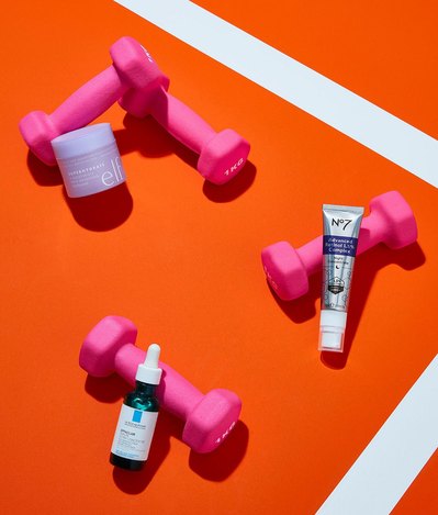 A visually captivating arrangement featuring three different cosmetics products elegantly placed on a pink dumbbell-shaped support, This aesthetically pleasing composition is skillfully photographed by David Lineton, an expert in London makeup still-life.