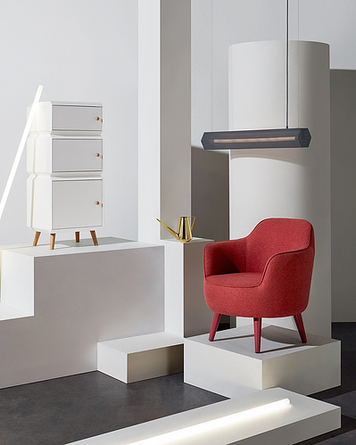 A meticulously composed interior scene featuring a chair elevated on an object, a lamp in front of the chair, and a table also placed on an object. This expertly crafted image is captured by David Lineton, a specialist in commercial still life photography
