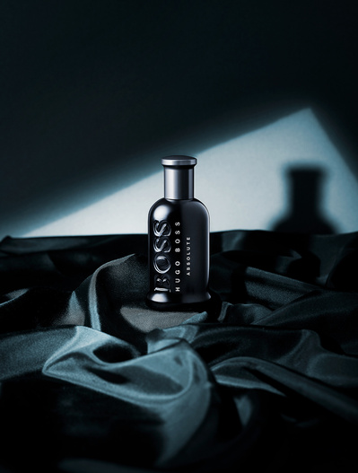 A striking composition featuring a black perfume bottle, elegantly placed on a black surface, with a seamless black background. This minimalist and sophisticated image is skillfully photographed by David Lineton, an expert in fragrance photoshoot in Londo
