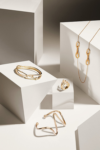 A professional arrangement showcasing a ring and other jewelry artfully placed on a white surfaces. This visually appealing composition is skillfully photographed by David Lineton, an expert in professional jewelry photography in London.