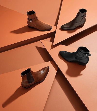 A stylish arrangement showcasing two black and two brown shoes, artfully placed on a brown surface. This chic composition is skillfully captured by David Lineton, an expert in product photography in London