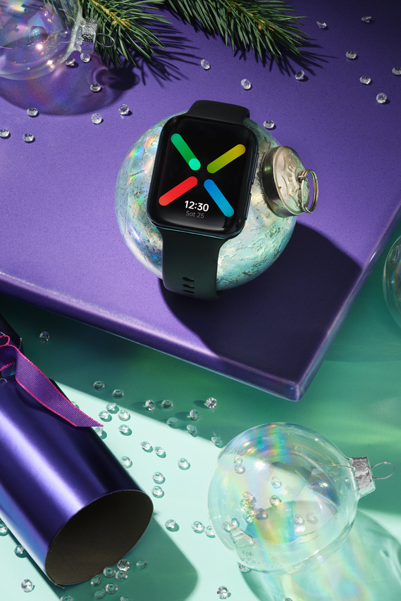 Digital wireless smart watch strapped around a Christmas bauble. 