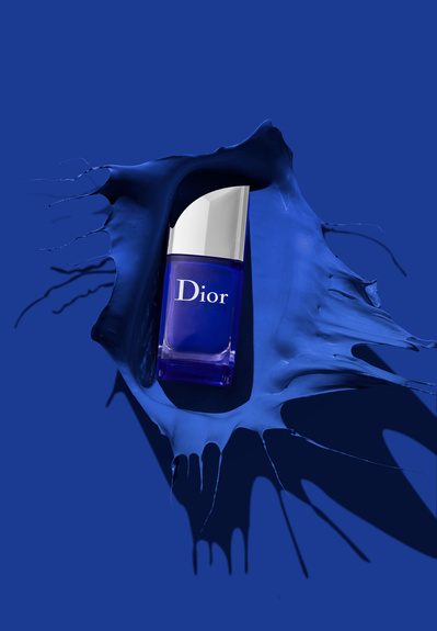 A striking presentation featuring a blue serum product positioned against a backdrop divided into two contrasting halves. This captivating composition is skillfully photographed by David Lineton, an expert in cosmetics photography. 