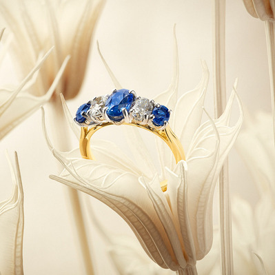 A captivating ring with three blue stones alternating with three white stones, artfully placed within a Flower Sculpture. This visually stunning composition is skillfully photographed by David Lineton, an expert in jewelry still life photography in London