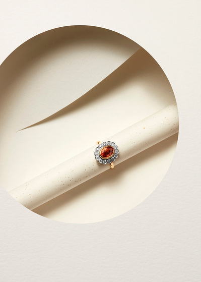 A captivating ring design featuring a large dark orange pearl surrounded by smaller white pearls. This visually striking composition is skillfully photographed by David Lineton, an expert in luxury product photography in London