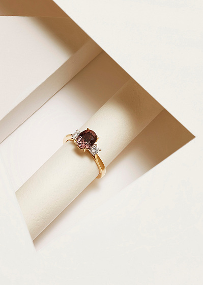 A sophisticated ring design showcasing a dark, big pearl positioned above a layer of smaller white pearls.This visually appealing composition is skillfully captured by David Lineton, an expert in luxury product photography in London