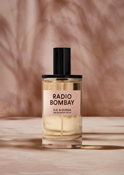 An elegant presentation featuring a 100 ml bottle of Radio Bombay perfume against a background matching its color. This sophisticated image is skillfully captured by David Lineton, an expert in perfume photography in London.
