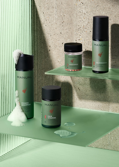 A sophisticated arrangement showcasing four distinct greenish bottles elegantly placed on mirrors. This refined presentation is skillfully photographed by David Lineton, an expert in London still-life photography. 