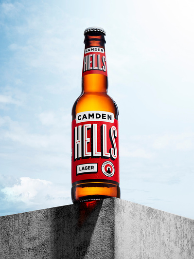 A unique perspective capturing a Camden Hells drink from below, placed on the surface right at the edge, Skillfully photographed by David Lineton, an expert in drink product photography in London