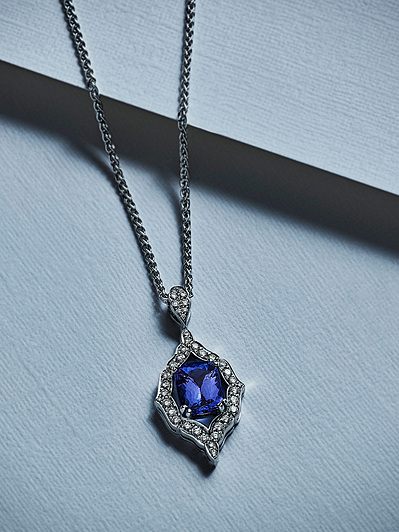 A captivating necklace featuring a blue stone surrounded by white pearls, skillfully photographed for ecommerce jewelry presentation in London by David Lineton, an expert in ecommerce jewellery photography.