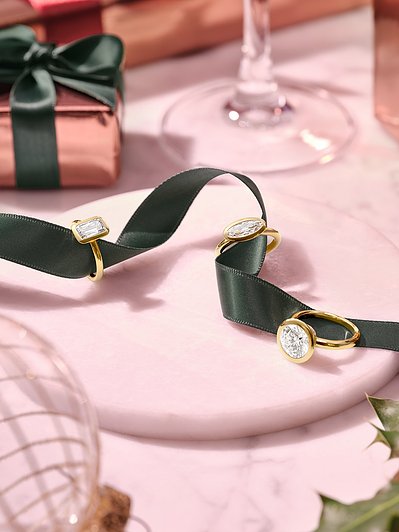 A captivating arrangement featuring three rings connected by a black ribbon, This visually appealing composition is skillfully photographed by David Lineton, an expert in jewelry product photography in London