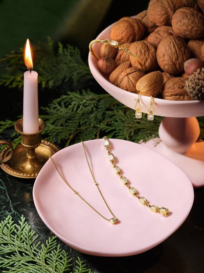 An artful composition featuring jewelry placed in a walnut plate, as well as within an empty plate. This visually appealing scene is skillfully photographed by David Lineton, an expert in commercial jewelry photography in London.