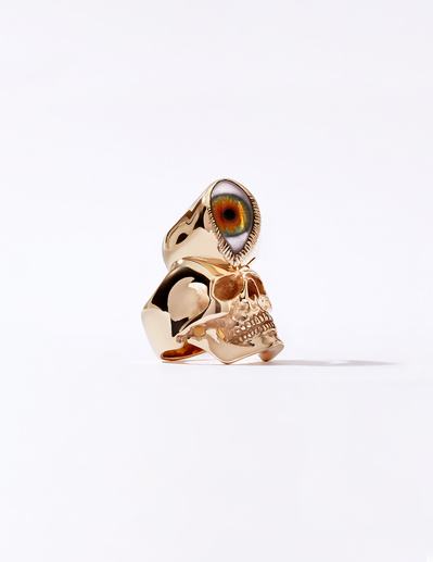 A unique and captivating composition featuring a ring with a big stone adorned with a greenish eye, artfully placed on a skull. This intriguing scene is skillfully photographed by David Lineton, an expert in jewelry photography services in London.