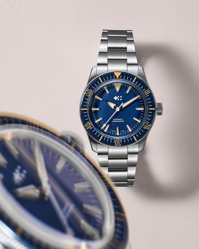Christopher Ward, a royal blue watch face with yellow highlights and dial framed by a macro motion blurred watch face close to the camera and the edge of the frame. Feature for Esquire Big Watch Book 2022
