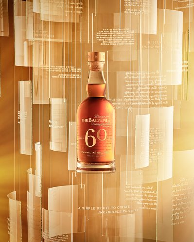 A compelling advertising composition showcasing a wine bottle with the prominent label displaying the number "60" along with its brand identity. Skillfully photographed by David Lineton, an expert in commercial drinks photography in London.