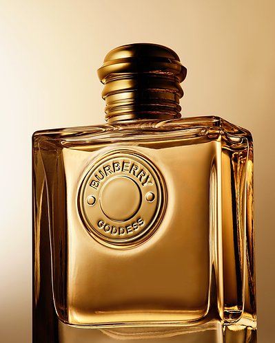 A captivating close-up photograph showcasing a golden perfume bottle, skillfully captured in an advertising photography style. This alluring image is the work of David Lineton, an expert in perfume advertising photography in London.