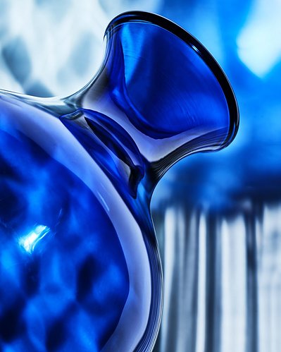 A captivating composition featuring a large base bluish bottle captured from a bottom-up perspective. This visually striking image is expertly captured by David Lineton, a specialist in still life object photography in London.