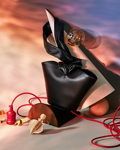 A chic and stylish black bag is showcased along with other accessories in this well-composed image. Expertly captured by David Lineton, a professional accessories photographer in London.