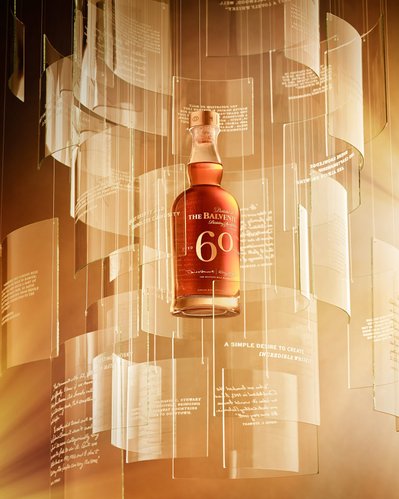 An artistic and gravity-defying capture of a wine bottle, appearing suspended in the air, with the prominent number "60" elegantly inscribed on it, tailored for advertising purposes. This visually captivating image is skillfully photographed by David Line