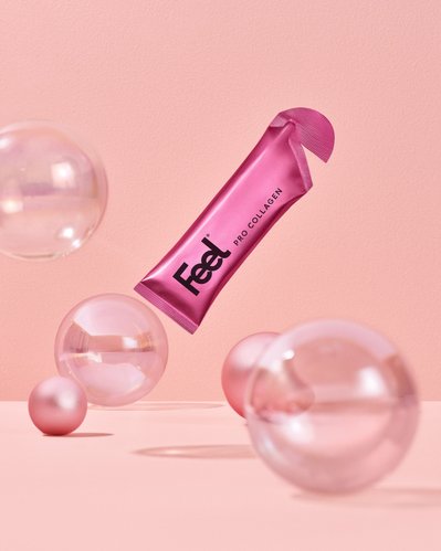 A captivating presentation featuring the beauty product named "Feel," elegantly placed amidst five different-sized bubble-type balls. This aesthetically pleasing image is skillfully photographed by David Lineton an expert still-life photographer in London