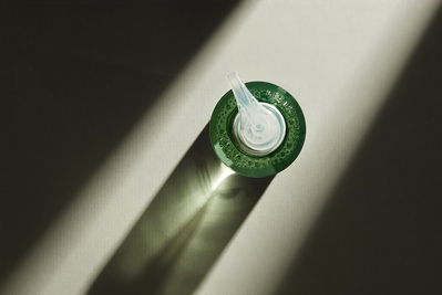 A stunning top view photograph highlighting a cosmetic product against a dark background, with focused lighting exclusively on the product. This minimalist and impactful composition is skillfully captured by David Lineton, an expert in London beauty makeu