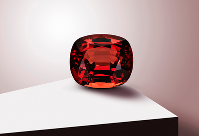 A close-up photograph capturing the intricate details of a reddish pearl stone elegantly placed on a white table. This visually striking image is skillfully photographed by David Lineton, an expert in luxury product photography in London