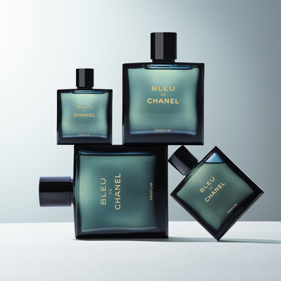 A stylish arrangement showcasing four perfume bottles, gracefully balanced on one another, creating an aesthetically pleasing composition. This captivating image is skillfully photographed by David Lineton, an expert perfume photographer in London