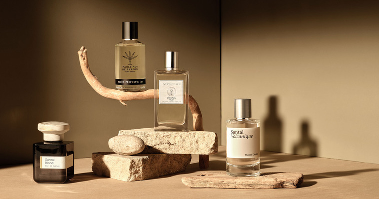 Golden sandy sunset lighting with perfumes balanced on a stick and smashed sandstone and pebbles. With Misinsir, Parle Moi De Parfum and Santal Blond Eau De Parfum