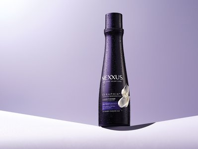 A captivating advertisement showcasing Nexxus conditioner, elegantly presented with glistening water droplets adorning the bottle. This exquisite image, emphasizing the product's freshness and quality, is expertly captured by David Lineton. 
