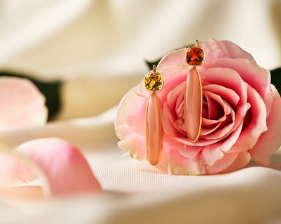 A captivating arrangement with two earring pieces elegantly suspended on a pink rose. This visually appealing composition is skillfully photographed by David Lineton, an expert in professional jewelry photography in London.