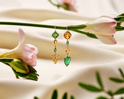 A stunning composition showcasing two beautiful pieces of earrings elegantly attached to a flower. This visually appealing scene is skillfully photographed by David Lineton, an expert in commercial jewelry photography in London