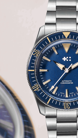 Moving Still life of the Christopher Ward watch, a royal blue watch face framed by a blurred watch face close to the camera and the edge of the frame. Feature for Esquire Big Watch Book 2022