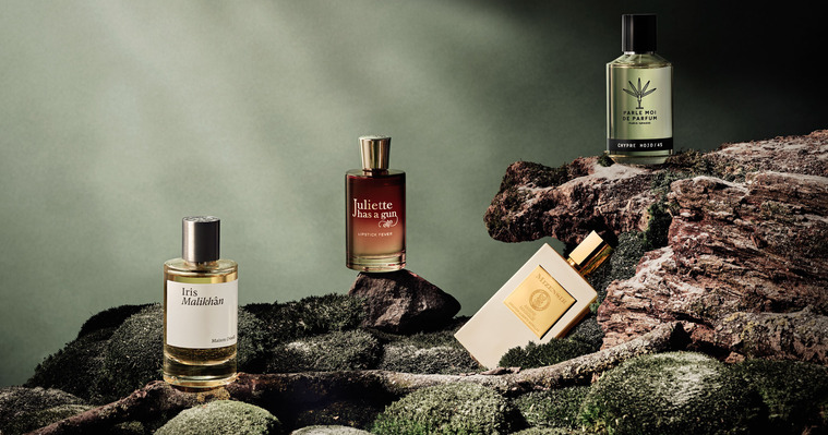 Frosty Green hues of mossy and earthy set built up like a cliff face. The Perfumes and Fragrances sit on branches and rocks. 