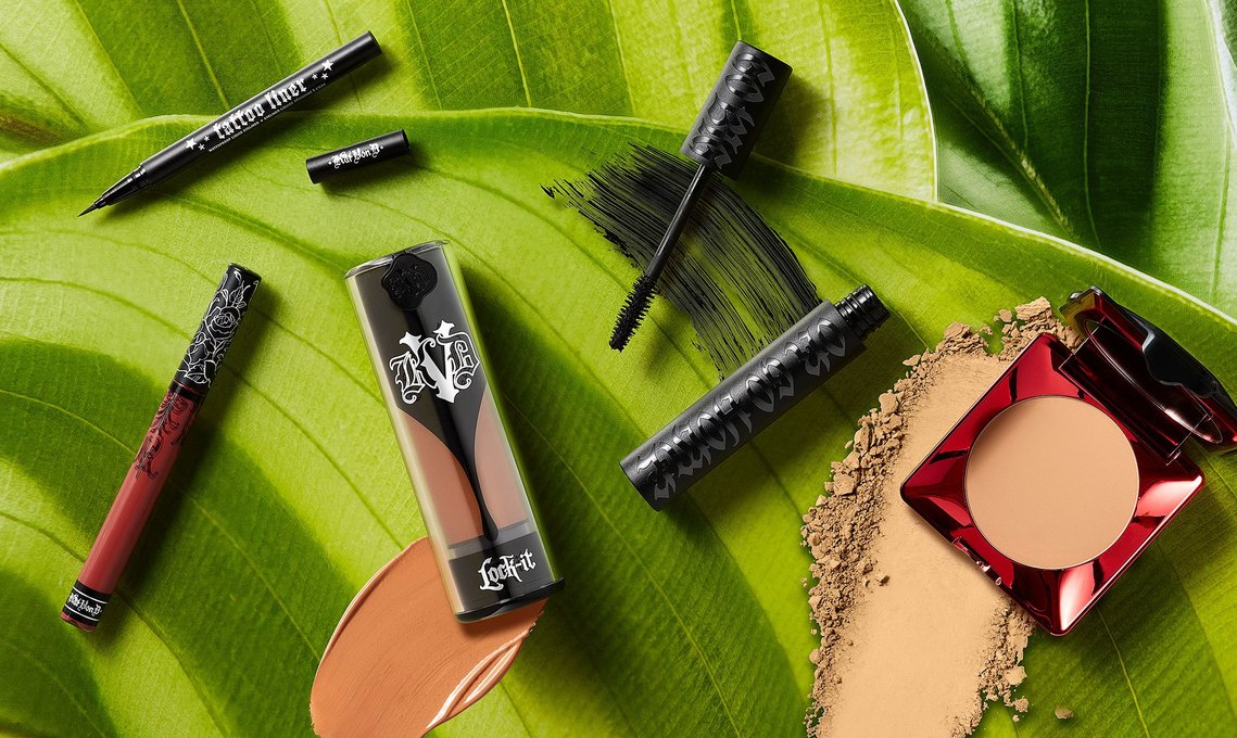 KVD Vegan Makeup and smudges photographed on green leaves image. With liquid foundation, powders and Mascara.