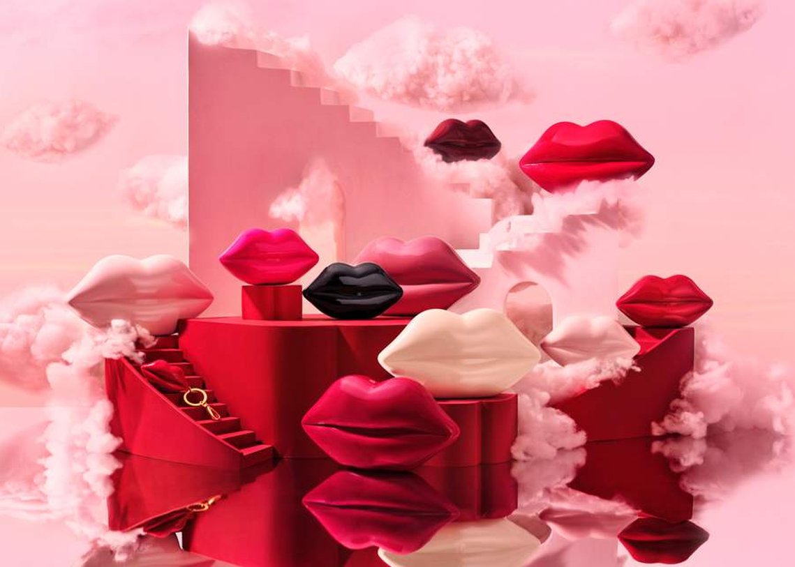 Mini and Nano Lip Handbags and small charm accessories sit on the curved lip staircase around the lips. A mirrored surface reflects the space giving it a surrealistic feel