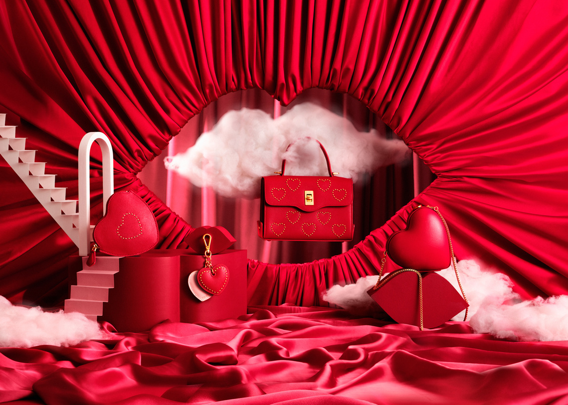 A vibrant Red fabric draped lip aperture frame up the Lulu Guinness Valentine's products. The stairways lead up to the small product accessories. 