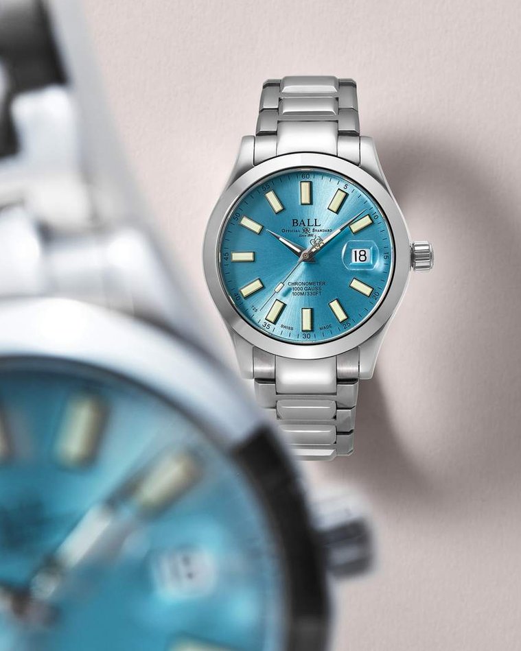 Ball Timepiece, an oyster blue watch face with glow-in-the-dark highlights and a dial framed by a macro movement blurred watch face close to the camera and the edge of the frame. Feature for Esquire Big Watch Book 2022