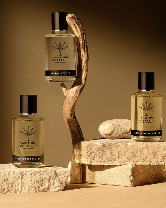 David Lineton Still Life Fragrance. Mizensir Perfume and Fragrances is balanced on a branch framed by a warm light. Perfumes stacked on fractured rocks.