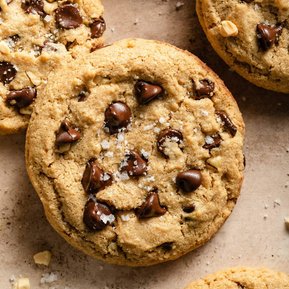 Large chocolate chip cookie with flaky sea salt on top.