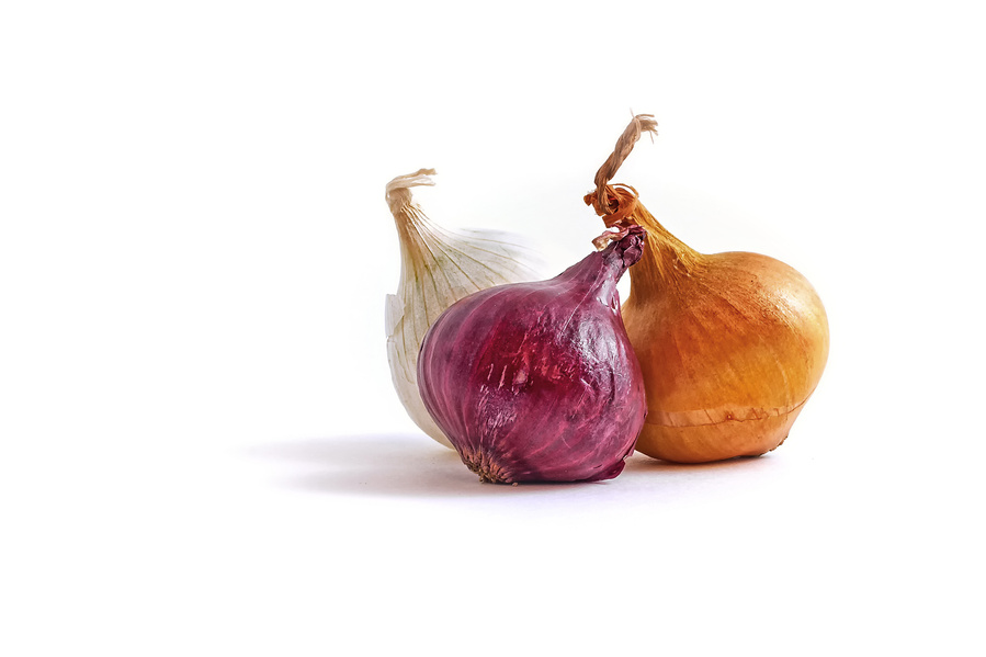 white, yellow and red pearl onions on a minimal white background