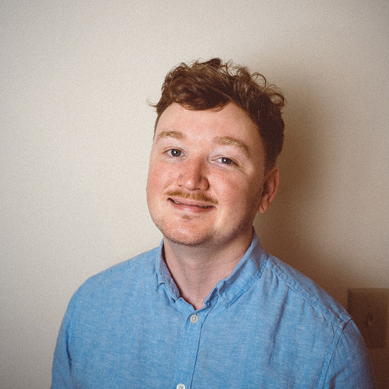 photo of colin in blue linen button down shirt smiling