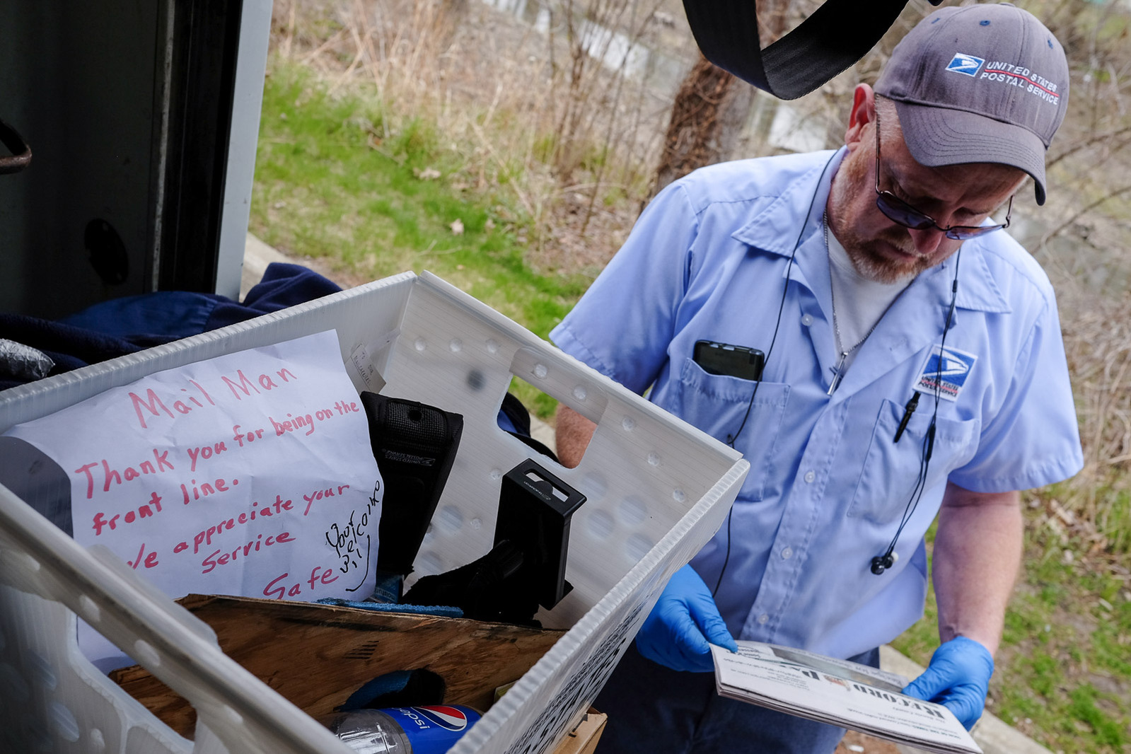 Mark Swan, a USPS letter carrier and President of the National Association of Letter Carrier’s 74th branch in Saginaw, sorts through packages in the cargo hold of his mail truck on Saturday, April 25, 2020 in Saginaw, Mich. In the mail crate is a thank-yo