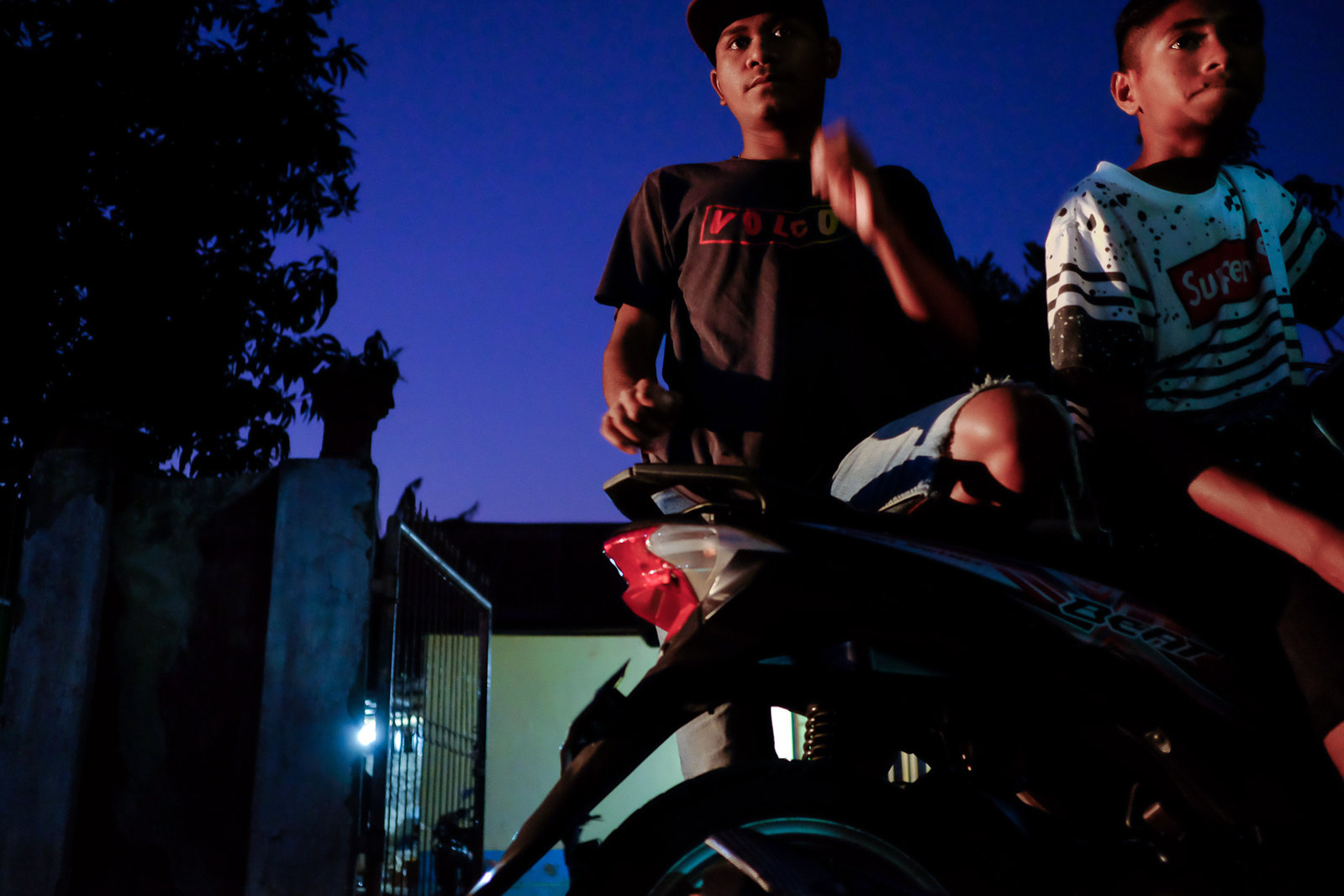 Young men loiter and relax by the side of the road in a residential neighborhood on September 20, 2019 in Kupang, Indonesia.