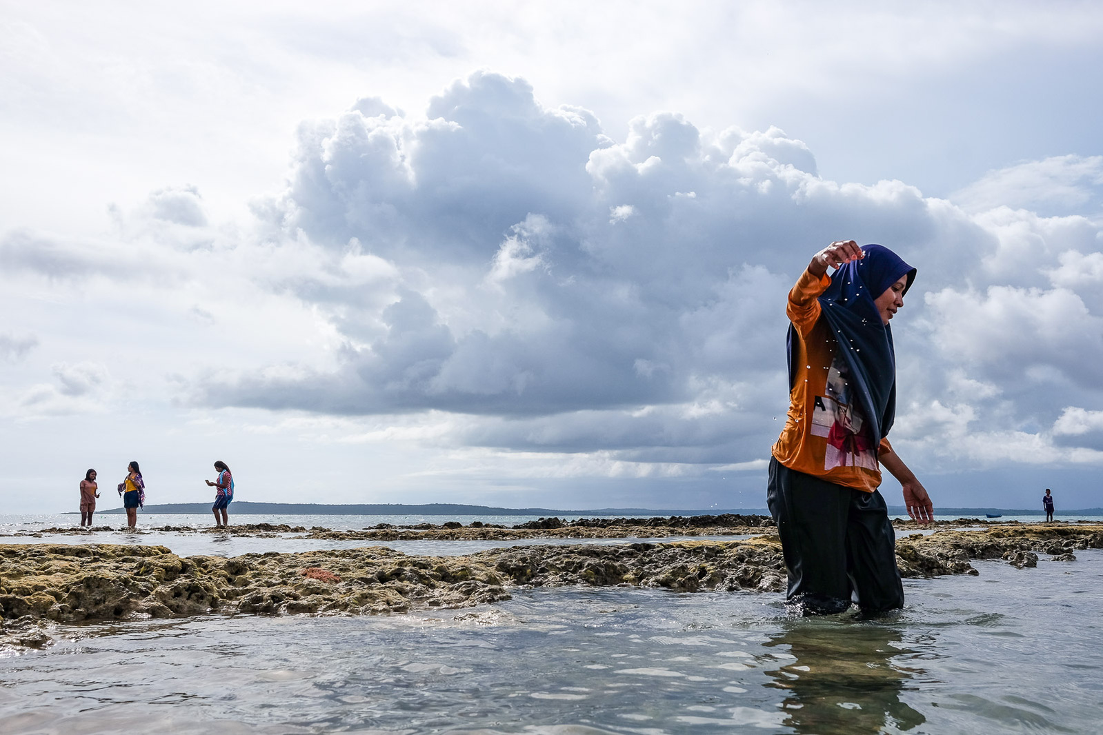 Beachgoers wade across tidepools and reefs on March 7, 2019 at Oesina Beach, 17 miles southwest of Kupang, Indonesia.
