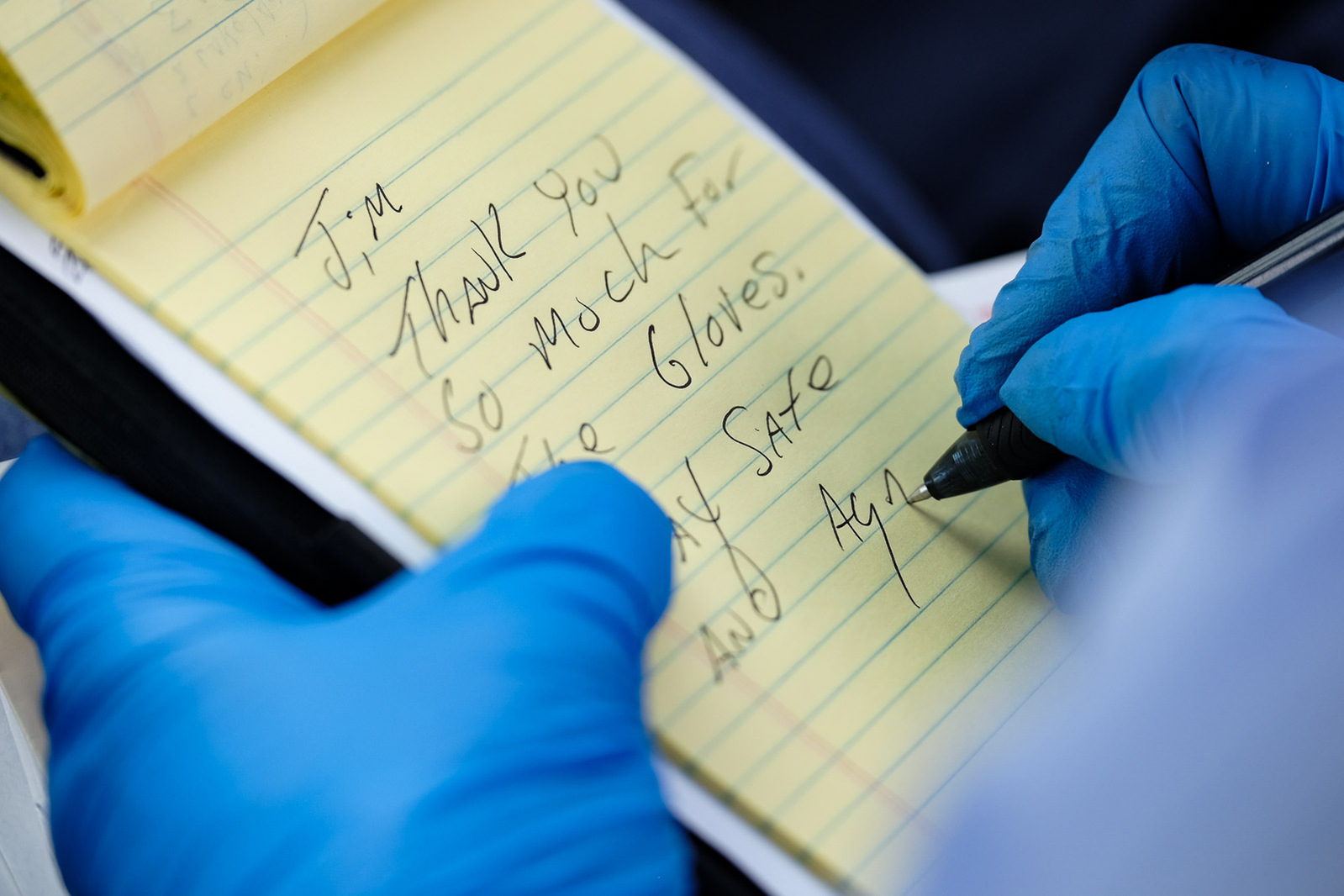 Mark Swan, a USPS letter carrier and President of the National Association of Letter Carrier’s 74th branch in Saginaw, writes a thank you note to a dentist on his delivery route who had left a box of nitrile gloves in his office’s mailbox on Saturday, Apr